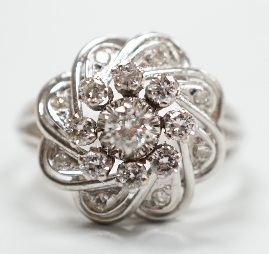 A French white metal (18ct poincon mark) and diamond cluster set dress ring, size L/M, gross weight4.8 grams.